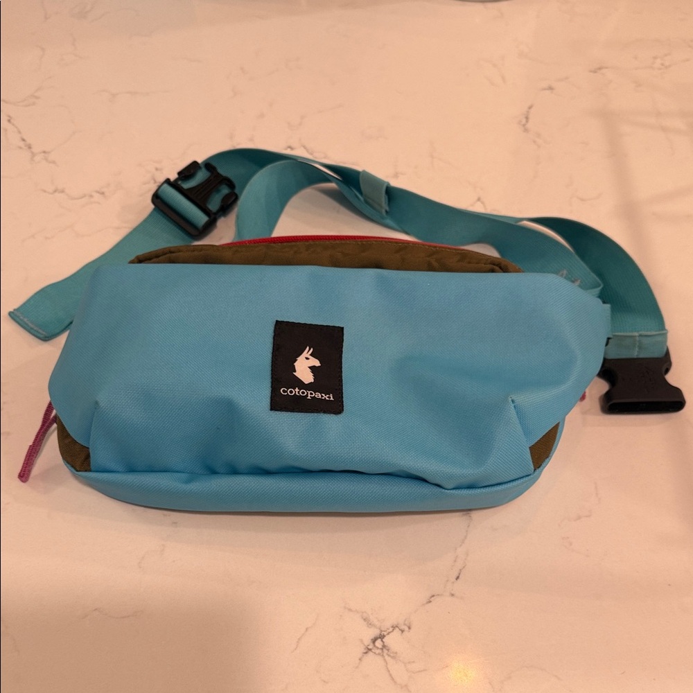 cotopaxi light blue waist pack with olive accents